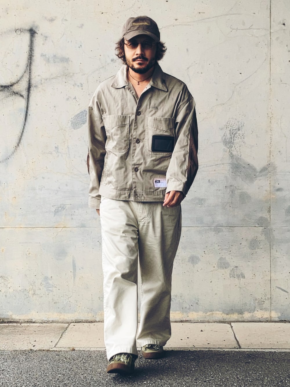 グリーン系のスニーカー、ベージュ系のその他アウター、ホワイト系のデニムパンツを着用したメンズの秋コーディネートの3枚目の写真