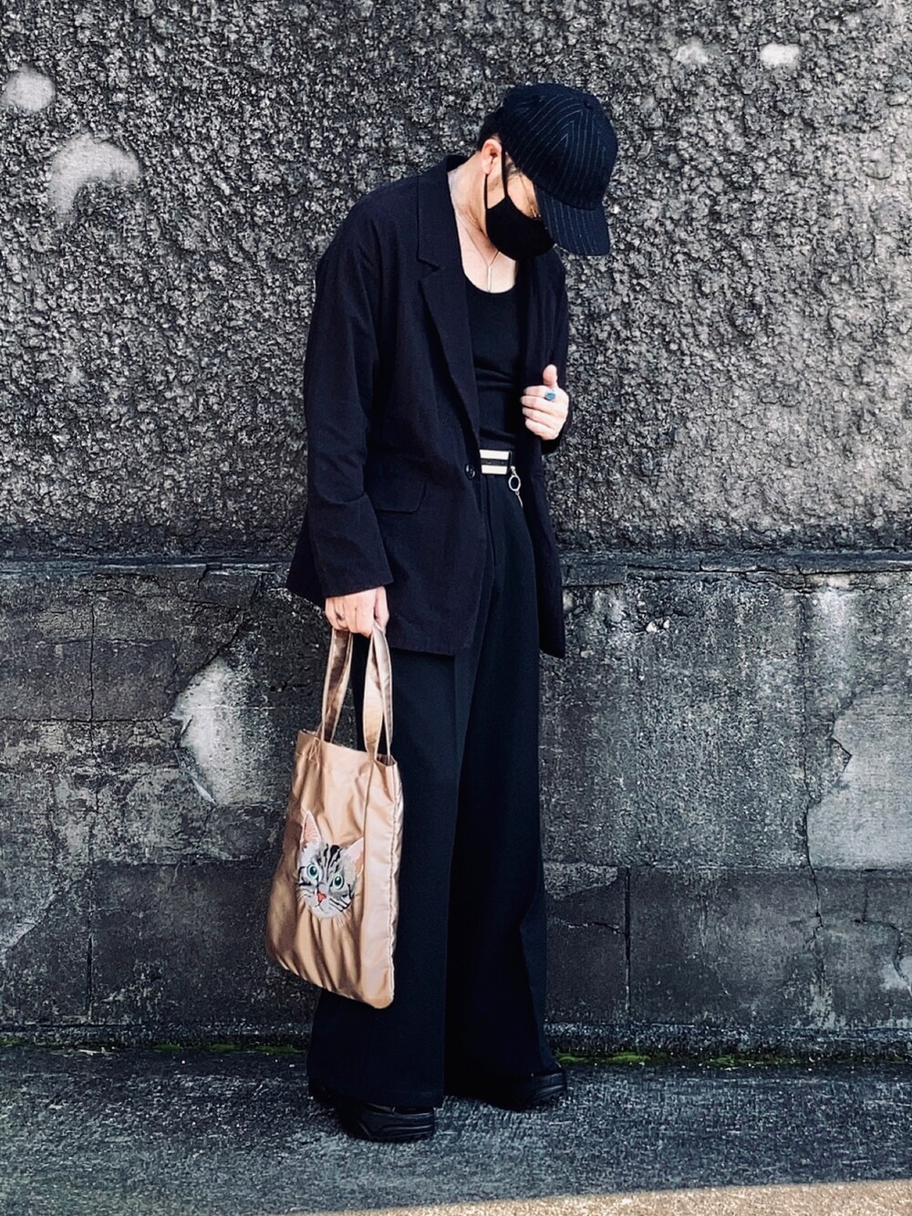 ブラック系のタンクトップ、ブラック系のテーラードジャケット、ブラック系のスラックスを着用したメンズの秋コーディネートの2枚目の写真