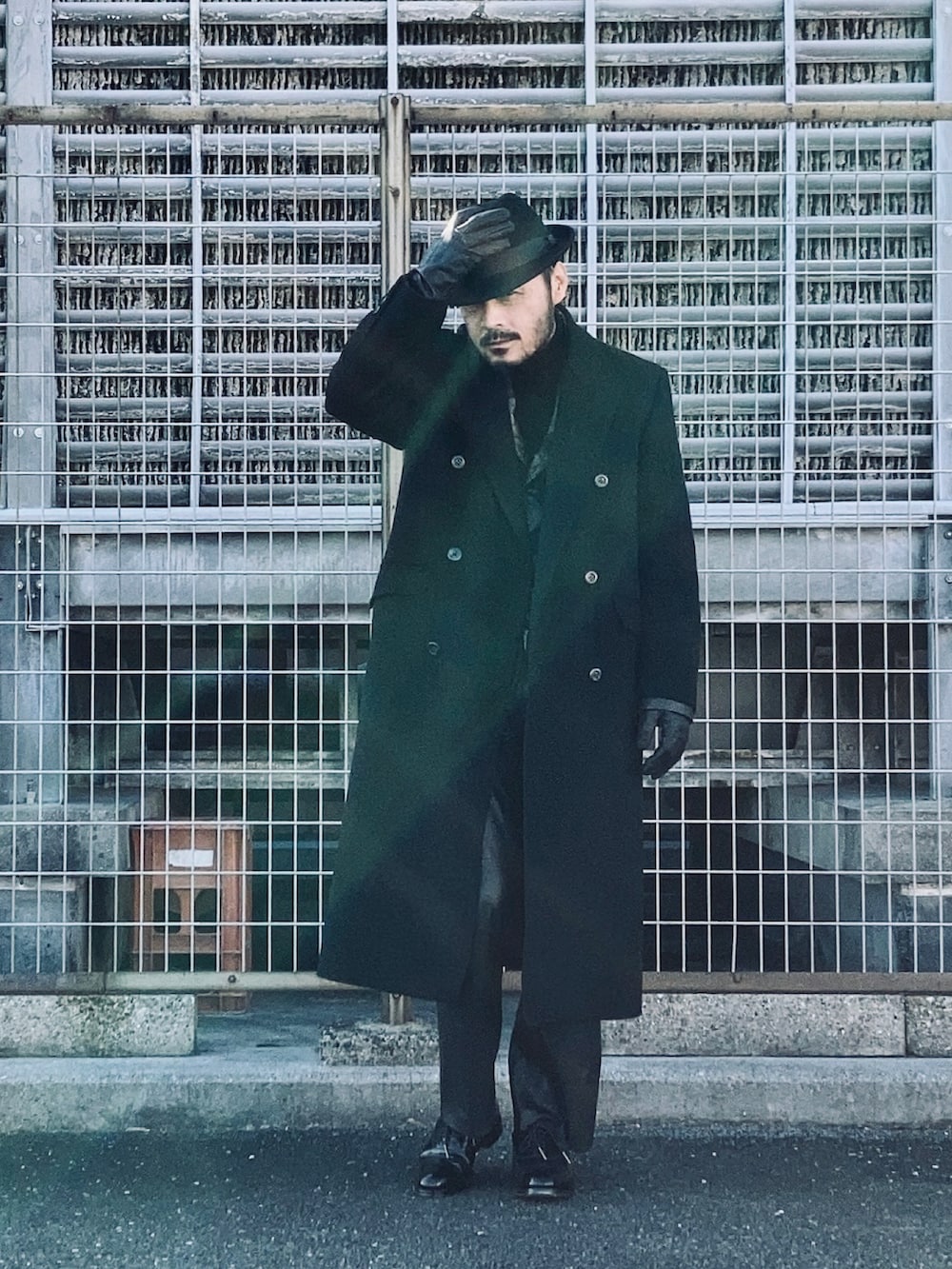 ブラウン系のテーラードジャケット、ブラック系のチェスターコート、ブラック系のニット/セーターを着用したメンズの冬コーディネートの3枚目の写真