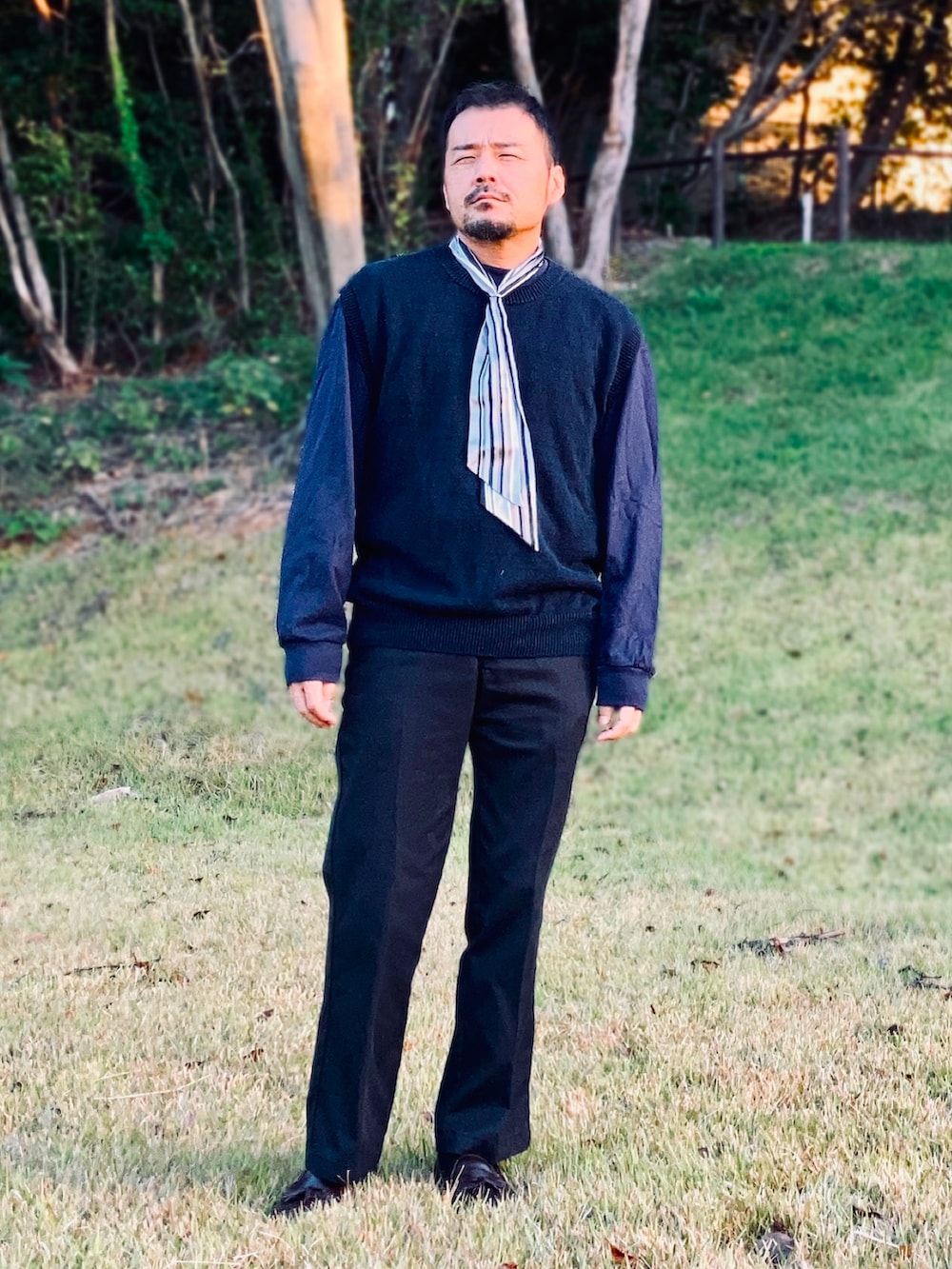 ブルー系のTシャツ/カットソー、ブルー系のベスト、ブルー系のチノパンツを着用したメンズの秋コーディネートの3枚目の写真