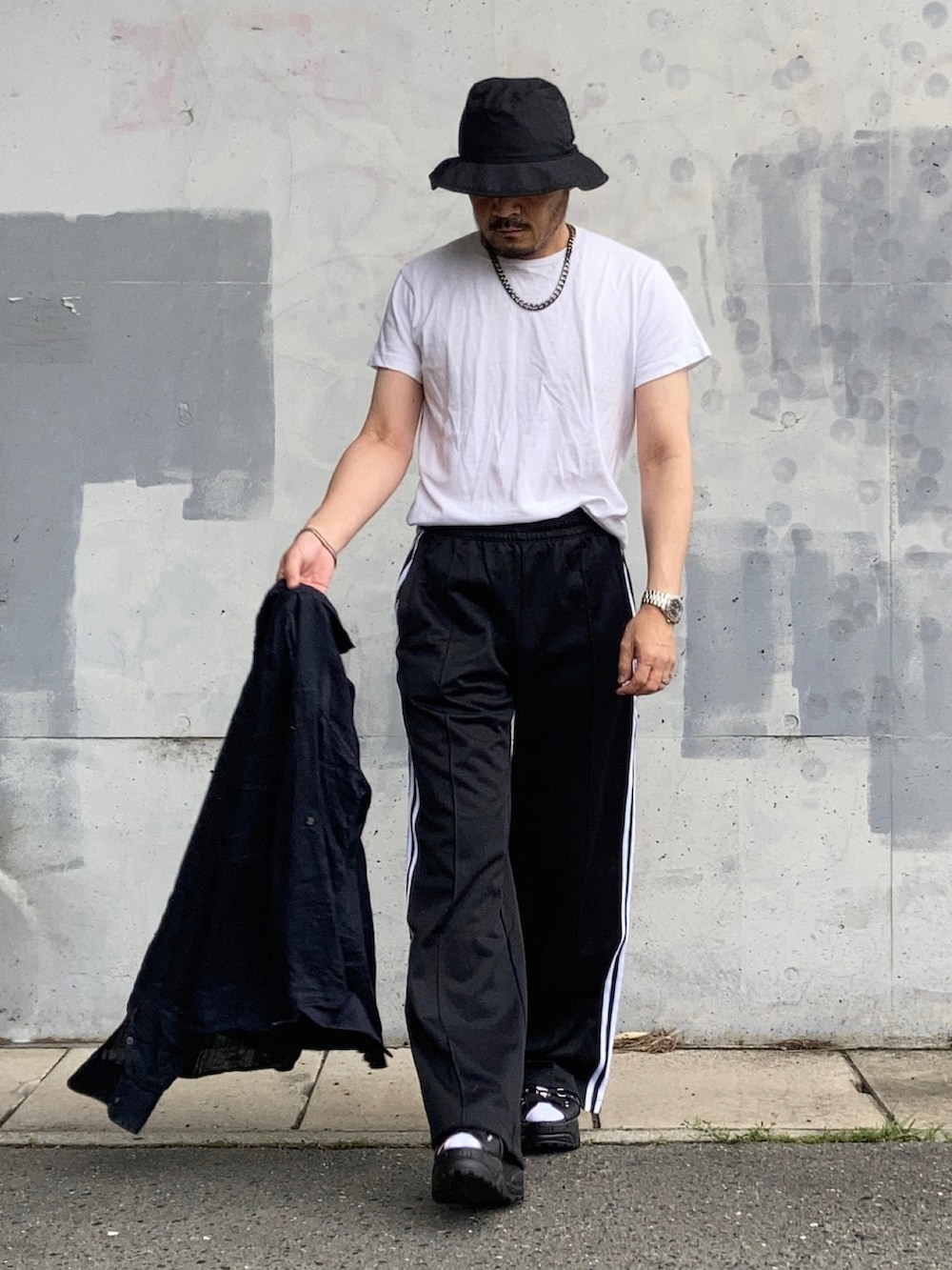 ホワイト系のTシャツ/カットソー、ブラック系のスウェットパンツ、ブラック系のサンダルを着用したメンズの夏コーディネートの2枚目の写真