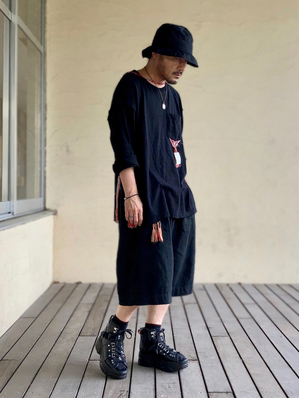 ブラック系のTシャツ/カットソー、ブラック系のその他パンツ、ブラック系のサンダルを着用したメンズの夏コーディネートの3枚目の写真
