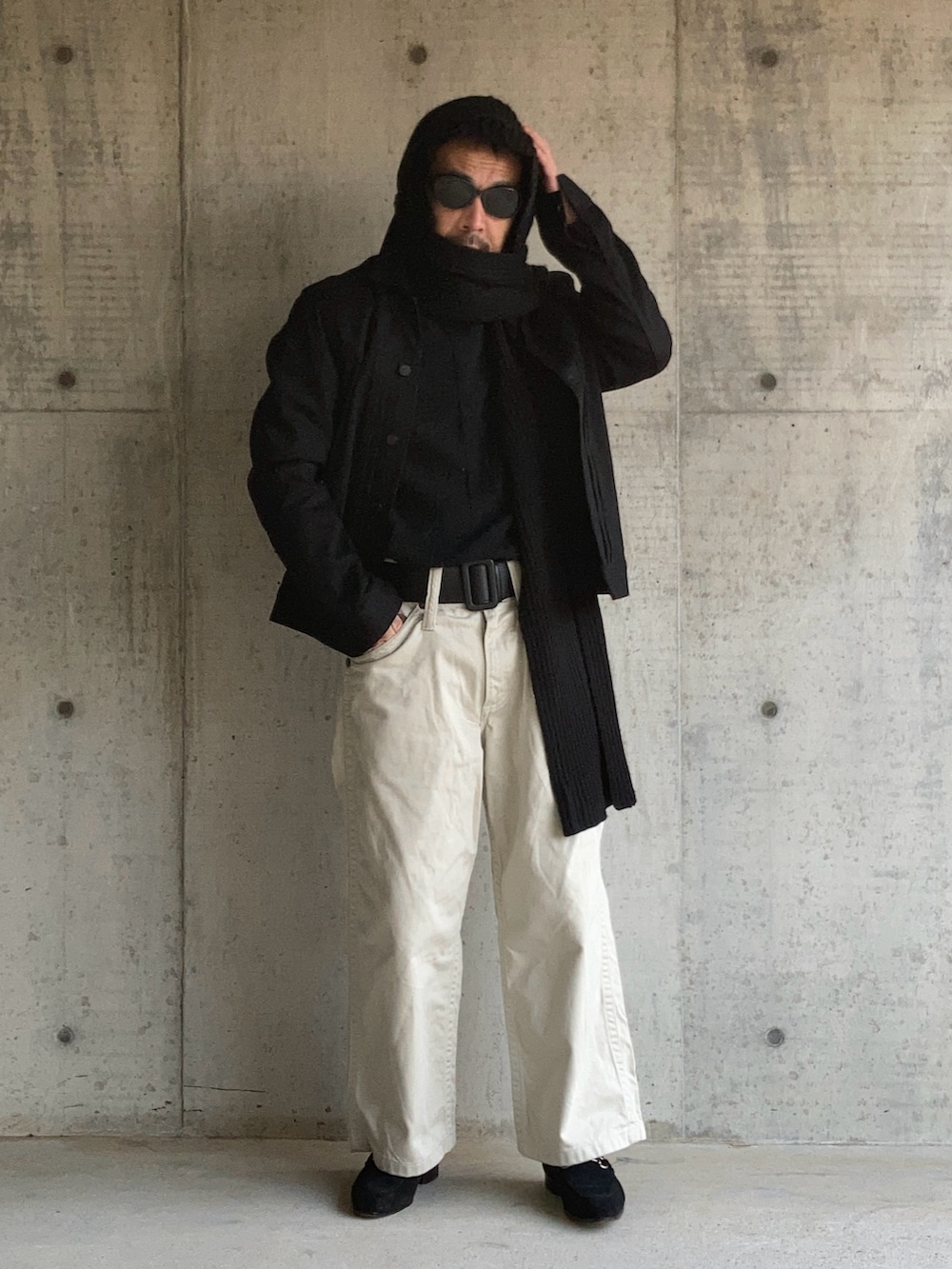 ブラック系のニット/セーター、ブラック系のデニムジャケット、ホワイト系のデニムパンツを着用したメンズの冬コーディネートの3枚目の写真