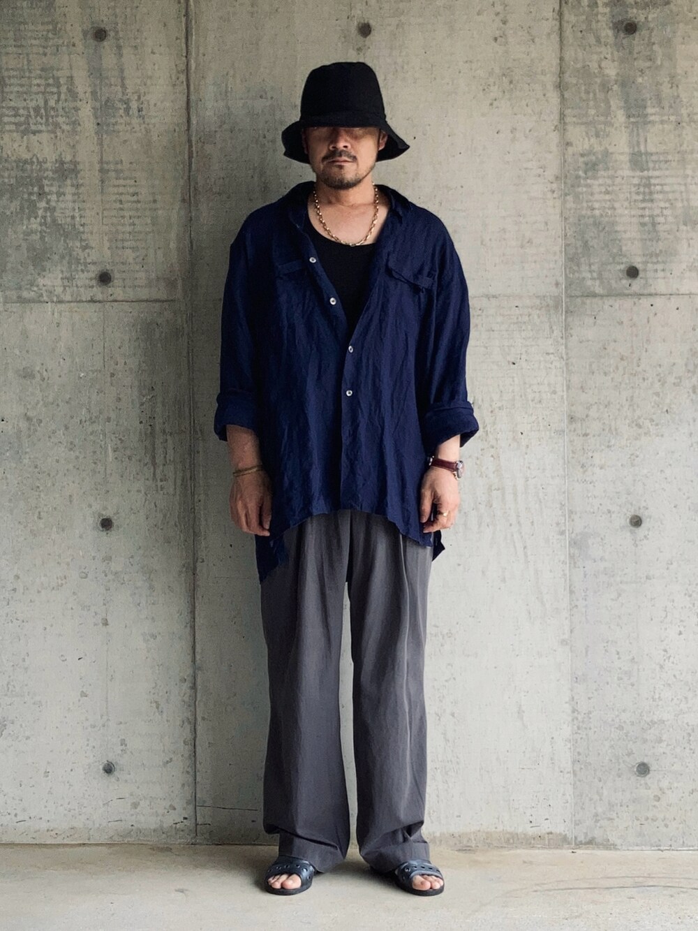 グレー系のスラックス、ブラック系のタンクトップ、ブルー系のシャツ/ブラウスを着用したメンズの春コーディネートの2枚目の写真