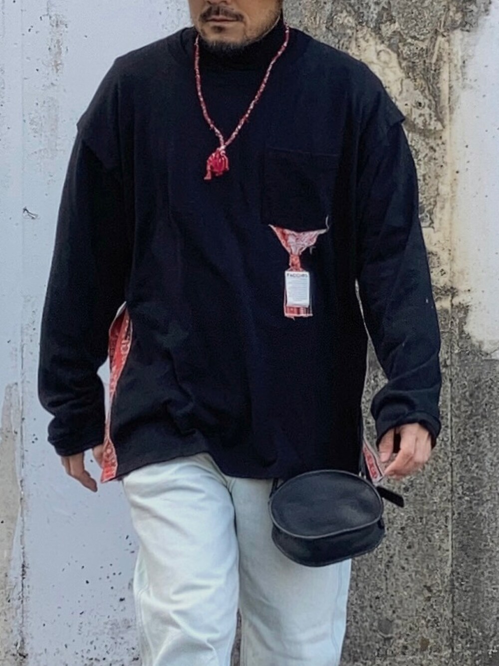 ブラック系のTシャツ/カットソー、ブルー系のデニムパンツ、レッド系のスニーカーを着用したメンズの冬コーディネートの4枚目の写真