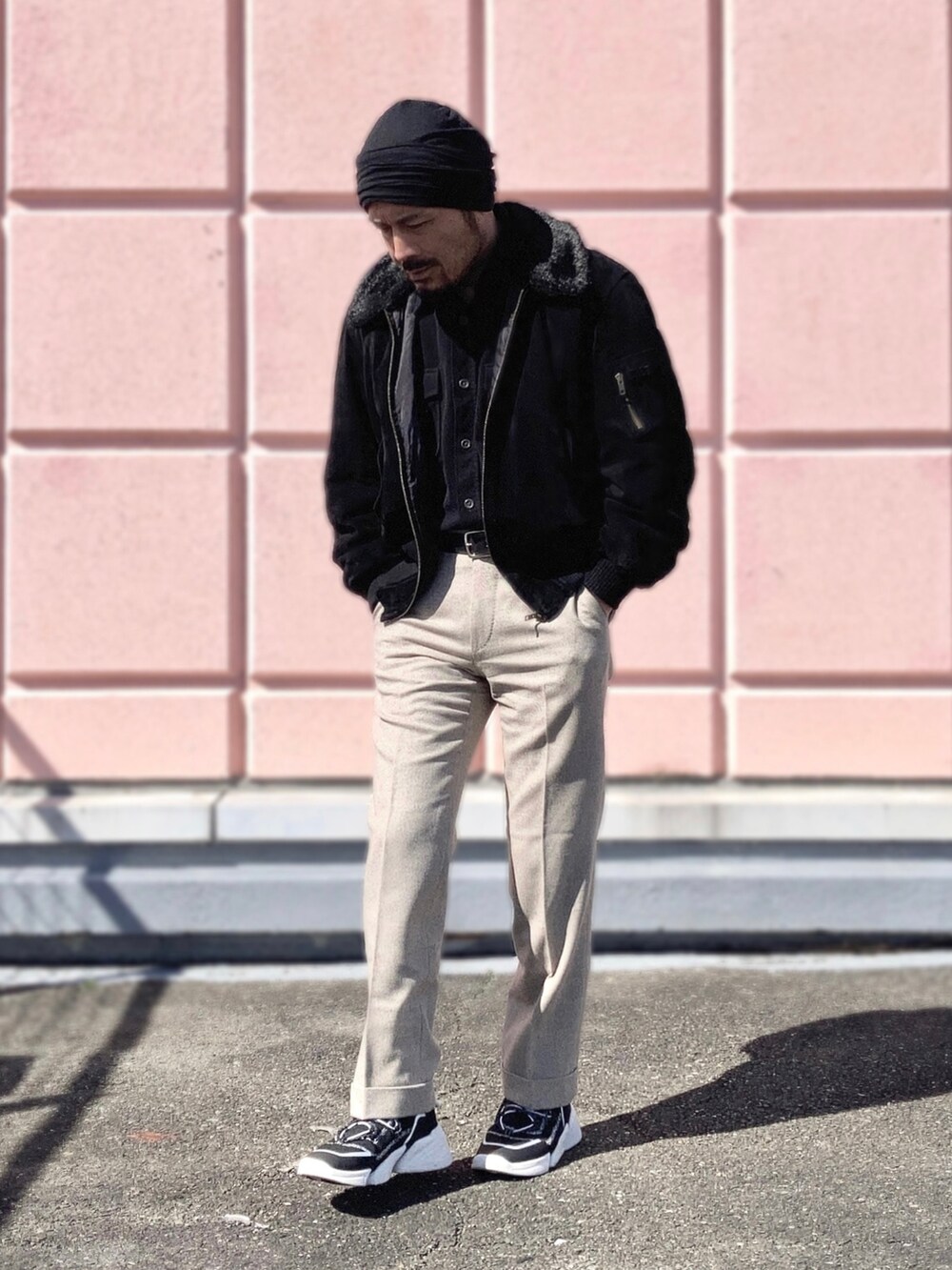 ブラック系のシャツ/ブラウス、ブラック系のブルゾン、ベージュ系のスラックスを着用したメンズの冬コーディネートの3枚目の写真