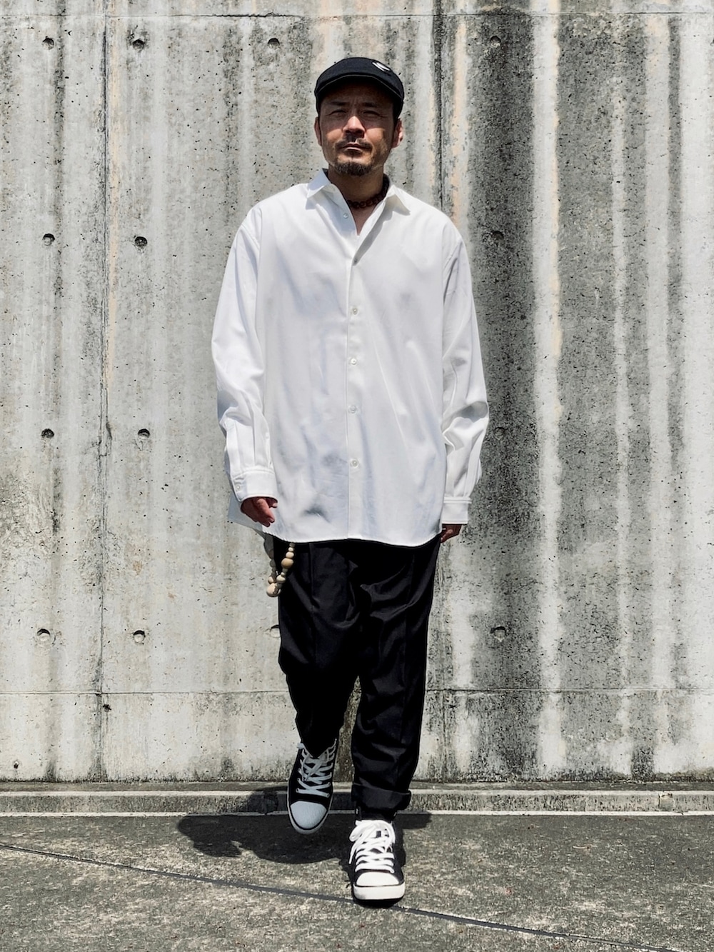 ホワイト系のシャツ/ブラウス、ブラック系のスラックス、ブラック系のスニーカーを着用したメンズの春コーディネートの4枚目の写真
