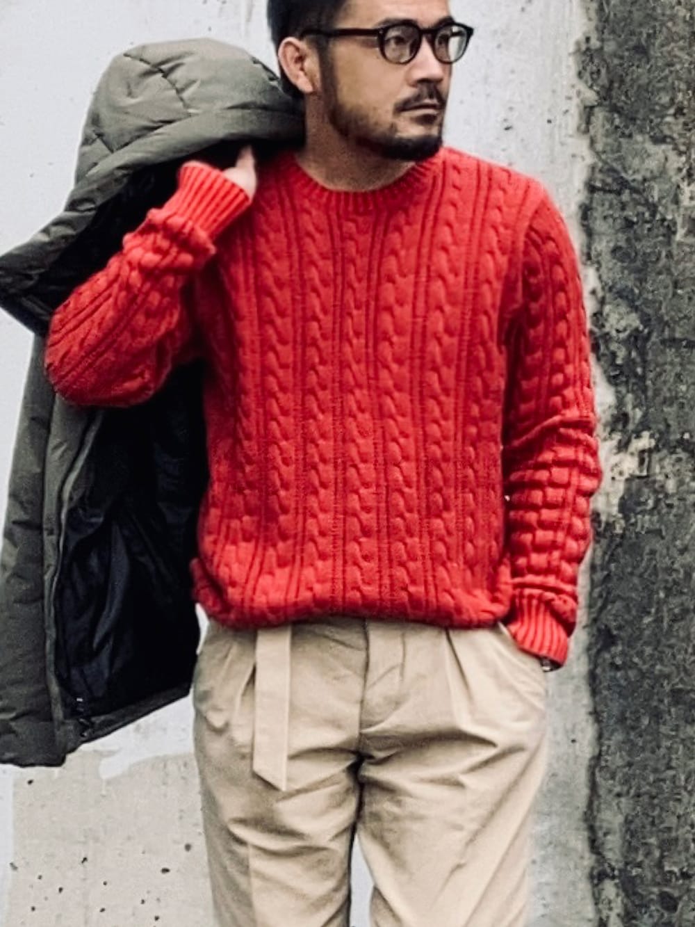 レッド系のニット/セーター、グレー系のジャケット/アウター、ベージュ系のスラックスを着用したメンズの冬コーディネートの2枚目の写真