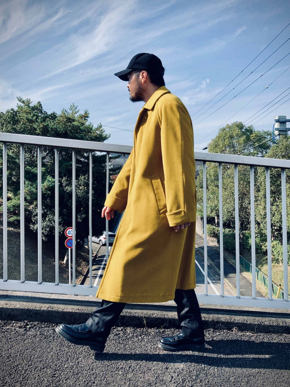 ブラック系のシャツ/ブラウス、イエロー系のステンカラーコート、ブラック系のその他パンツを着用したメンズの秋コーディネートの2枚目の写真