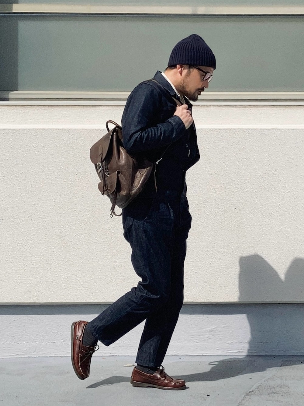 ブラウン系のバックパック/リュック、ブルー系のデニムジャケット、ブルー系のデニムパンツを着用したメンズの春コーディネートの3枚目の写真