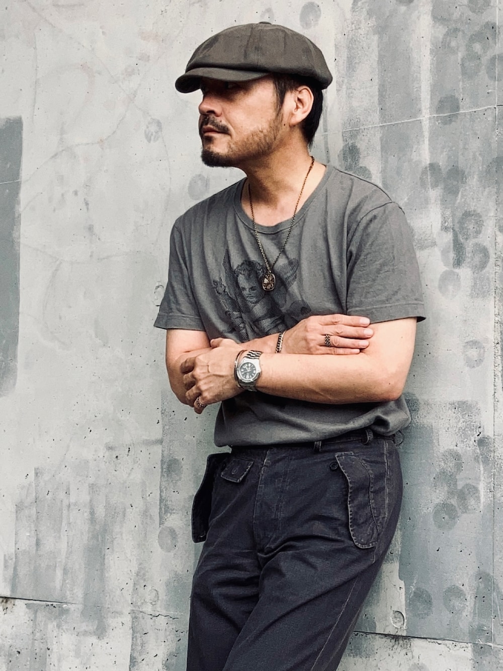 グレー系のTシャツ/カットソー、グレー系のスラックス、ブラック系のサンダルを着用したメンズの夏コーディネートの5枚目の写真