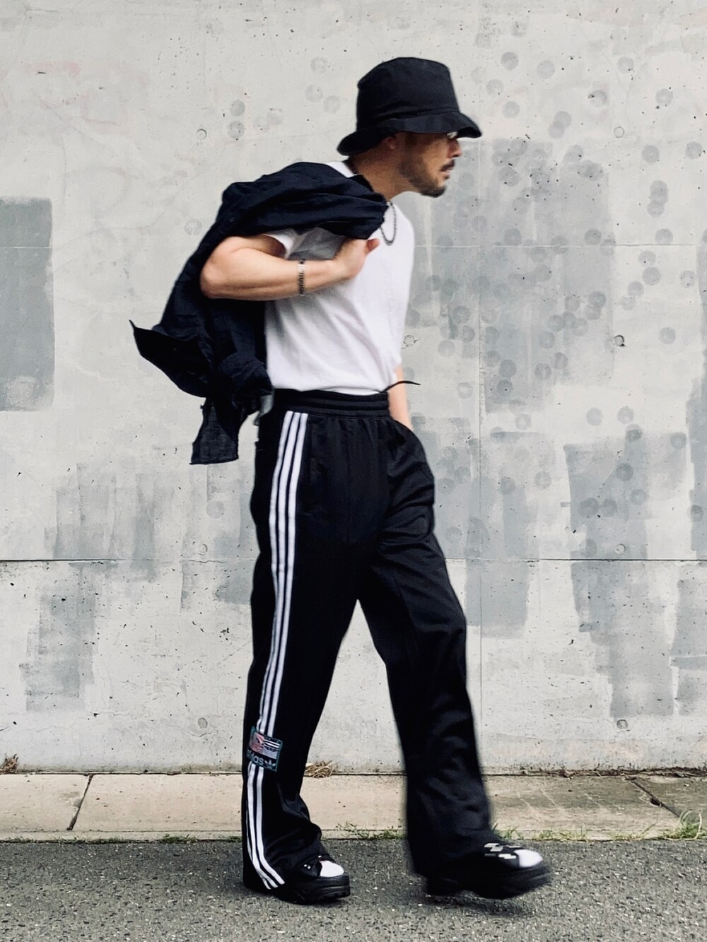 ホワイト系のTシャツ/カットソー、ブラック系のスウェットパンツ、ブラック系のサンダルを着用したメンズの夏コーディネートの3枚目の写真