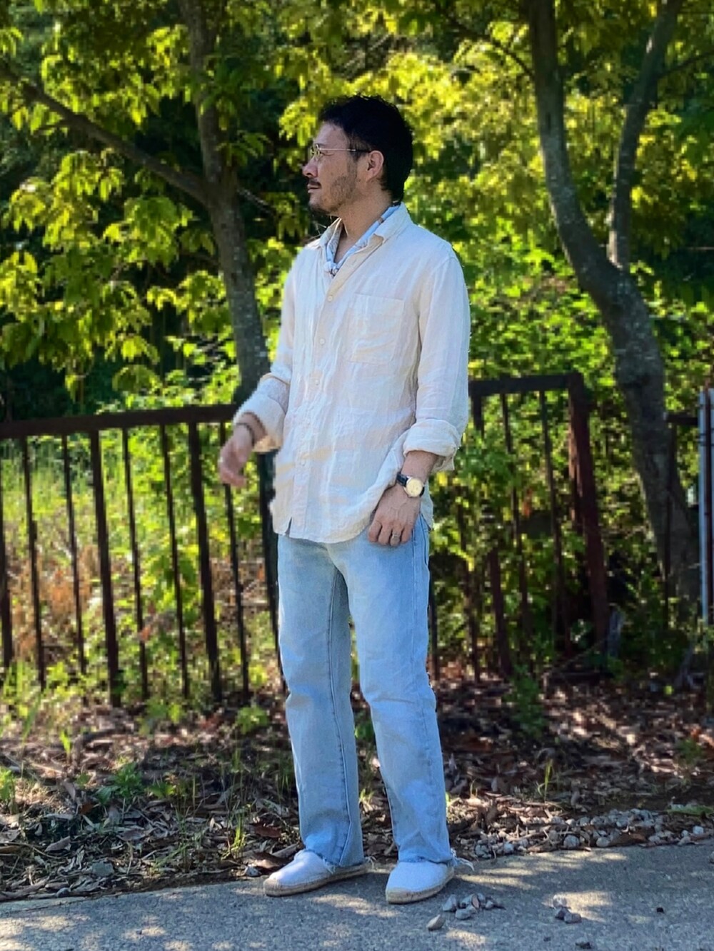 ベージュ系のシャツ/ブラウス、ブルー系のデニムパンツ、ホワイト系のスリッポンを着用したメンズの夏コーディネートの2枚目の写真