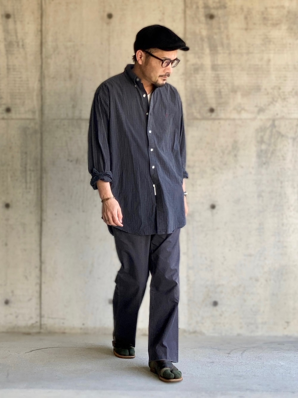 ホワイト系のTシャツ/カットソー、グリーン系のシャツ/ブラウス、グレー系のスラックスを着用したメンズの春コーディネートの2枚目の写真