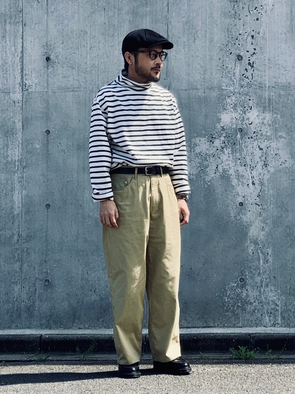 ブラック系のTシャツ/カットソー、ベージュ系のチノパンツ、ブラック系のローファーを着用したメンズの春コーディネートの3枚目の写真