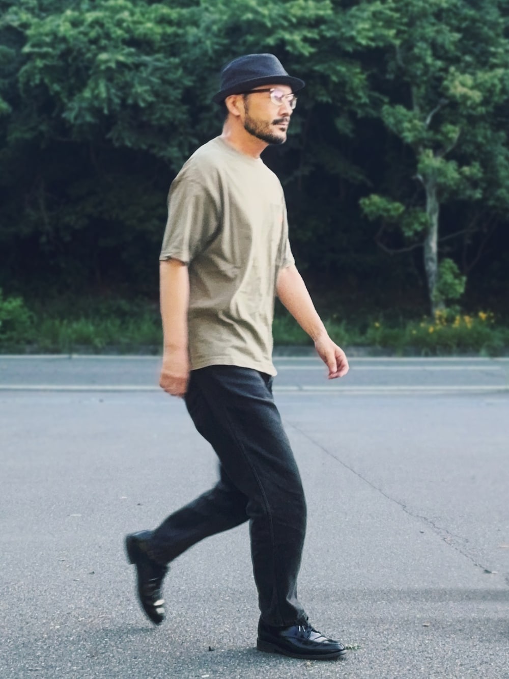 ブラック系のドレスシューズ、グリーン系のTシャツ/カットソー、ブラック系のデニムパンツを着用したメンズの夏コーディネートの2枚目の写真