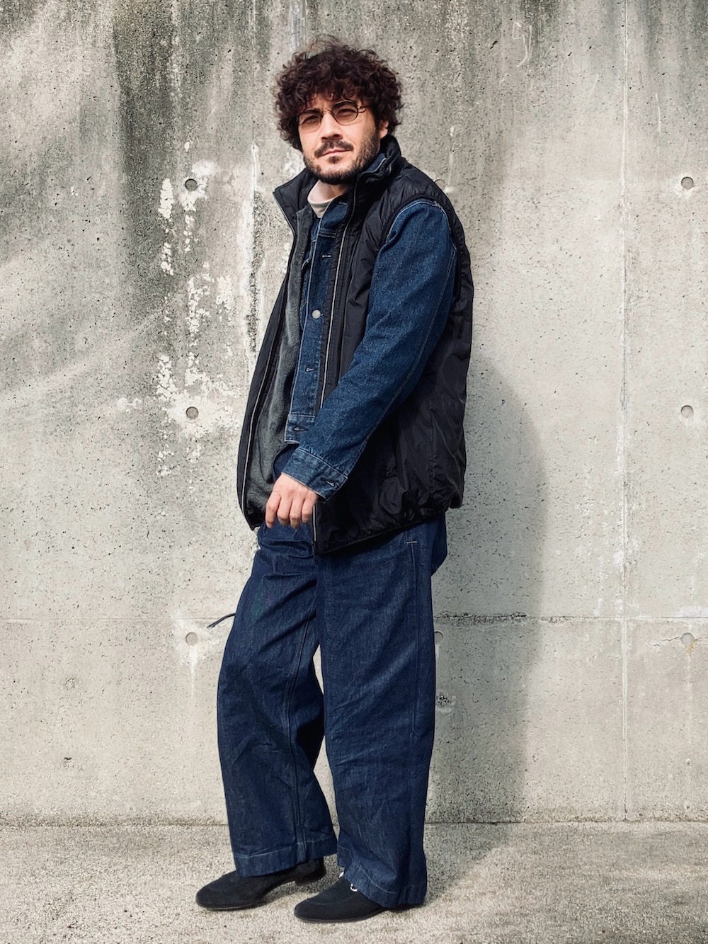 グレー系のTシャツ/カットソー、ブルー系のデニムジャケット、ブラック系のベストを着用したメンズの冬コーディネートの2枚目の写真