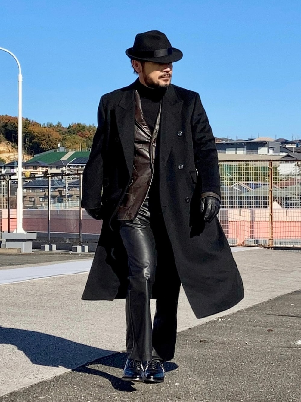 ブラウン系のテーラードジャケット、ブラック系のチェスターコート、ブラック系のニット/セーターを着用したメンズの冬コーディネートの4枚目の写真