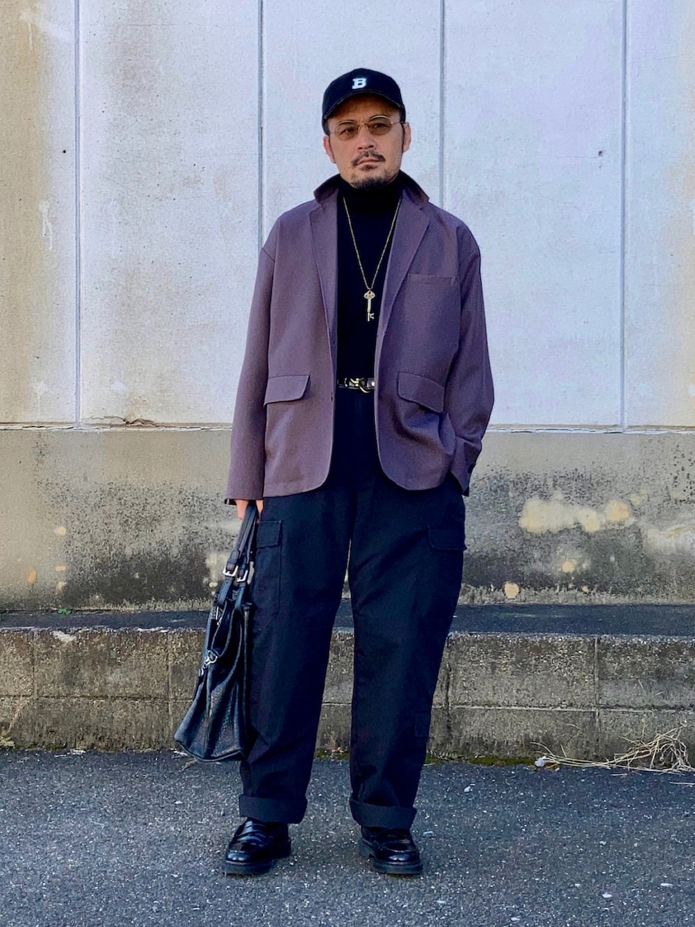 ブラック系のニット/セーター、グレー系のセットアップ、ブラック系のカーゴパンツを着用したメンズの秋コーディネートの3枚目の写真