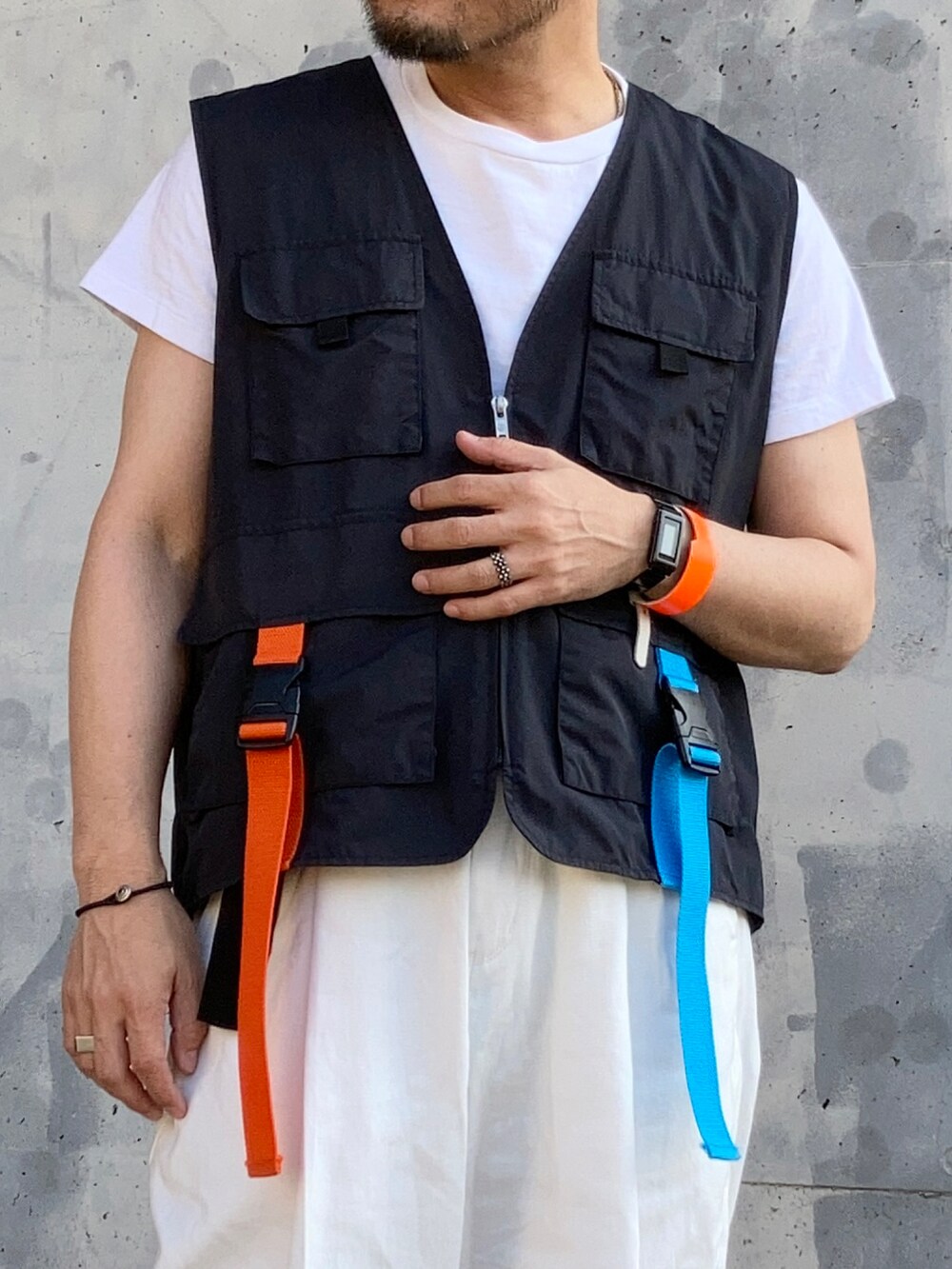 ブラック系のTシャツ/カットソー、ブラック系のベスト、ホワイト系のスラックスを着用したメンズの春コーディネートの3枚目の写真