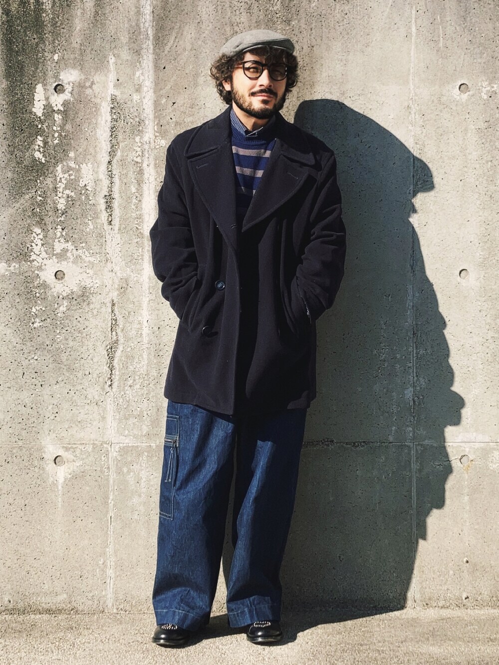 ブルー系のニット/セーター、ブルー系のピーコート、ブルー系のデニムパンツを着用したメンズの冬コーディネートの2枚目の写真