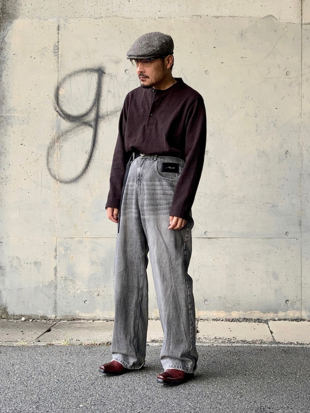 ブラウン系のTシャツ/カットソー、グレー系のデニムパンツ、レッド系のブーツを着用したメンズの秋コーディネートの3枚目の写真