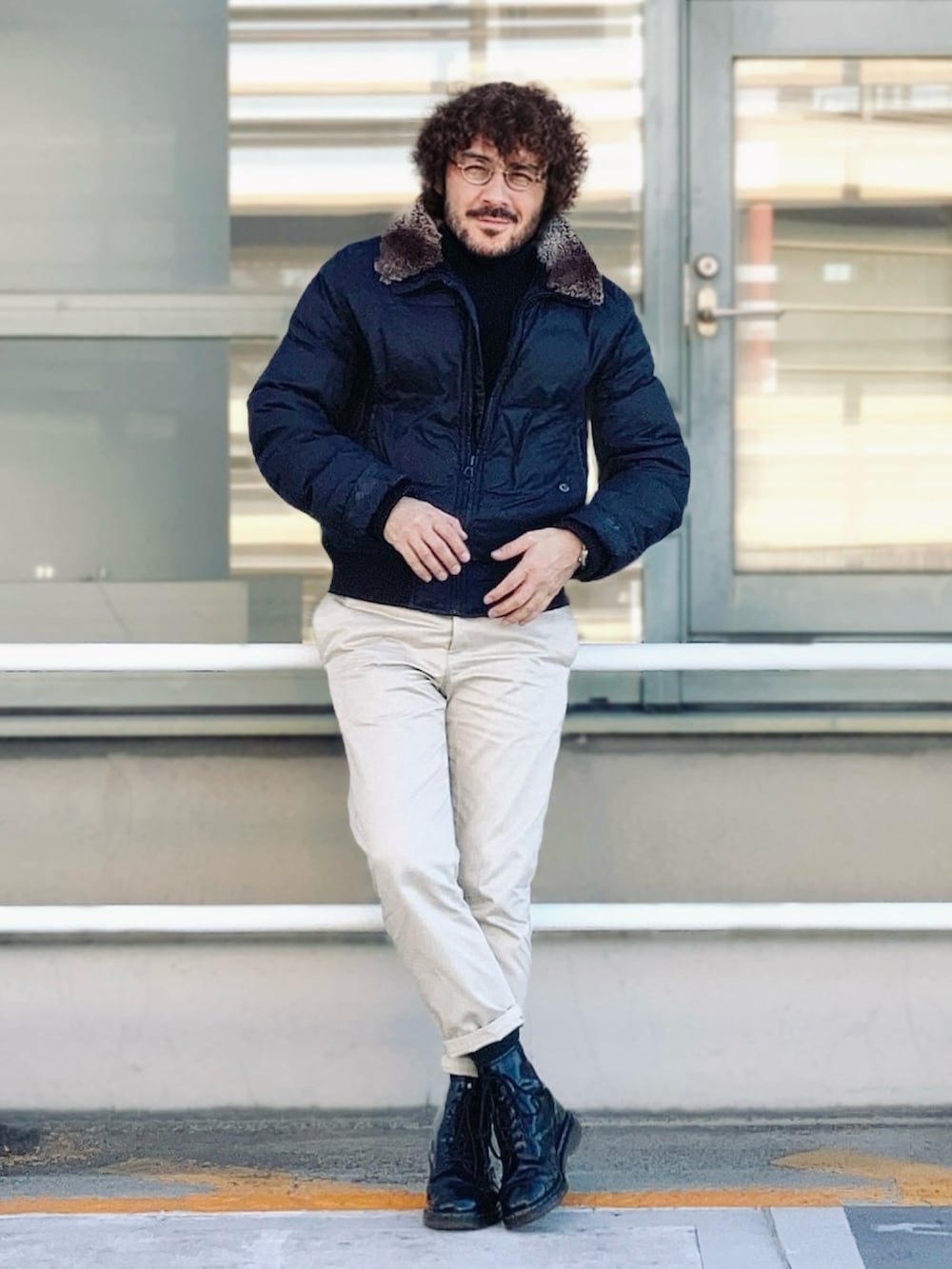 ブラック系のダウンジャケット/コート、ベージュ系のチノパンツ、ブラック系のブーツを着用したメンズの冬コーディネートの2枚目の写真