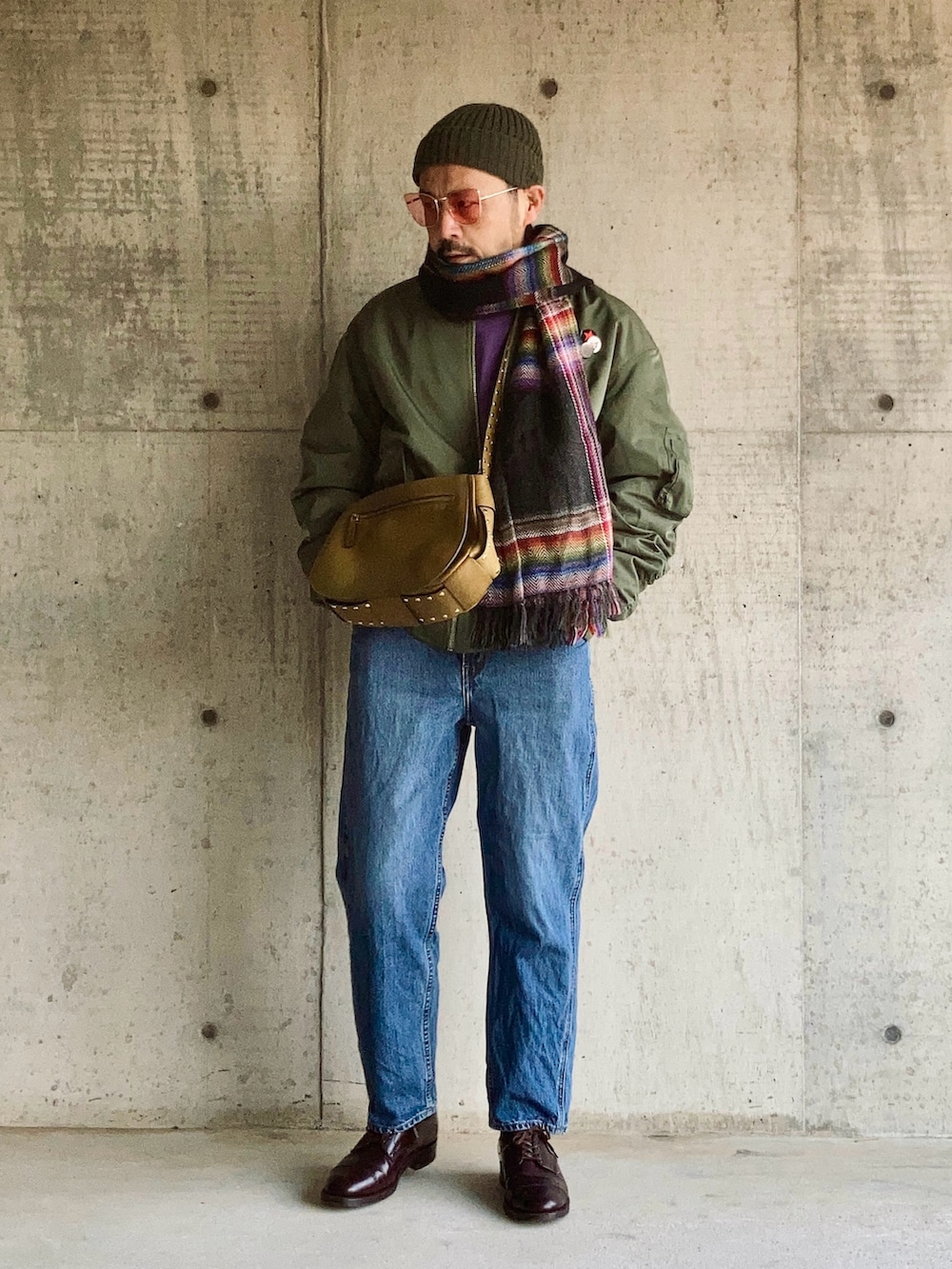 パープル系のスウェット、グリーン系のMA-1、ブルー系のデニムパンツを着用したメンズの冬コーディネートの5枚目の写真