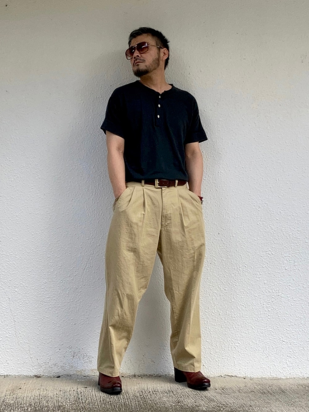 ブラック系のTシャツ/カットソー、ベージュ系のスラックス、レッド系のブーツを着用したメンズの秋コーディネートの2枚目の写真