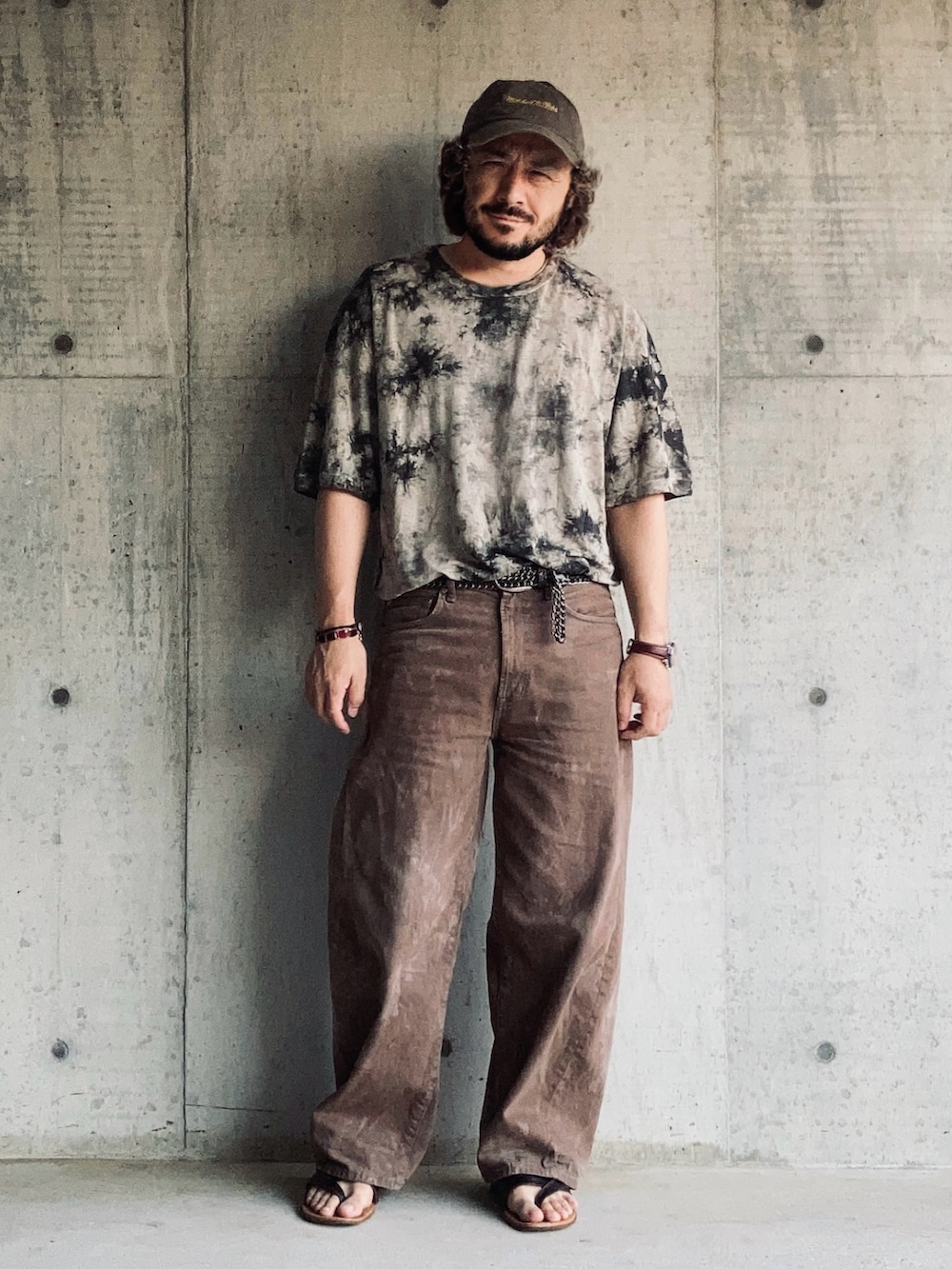 ブラウン系のTシャツ/カットソー、ブラウン系のデニムパンツ、ブラウン系のサンダルを着用したメンズの夏コーディネートの2枚目の写真
