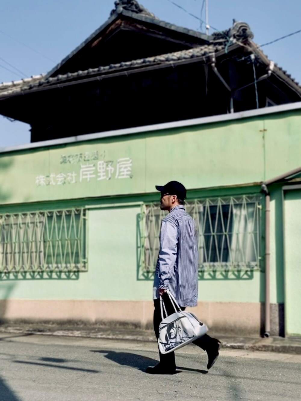 ブルー系のシャツ/ブラウス、ブラック系のスラックス、ブラック系のブーツを着用したメンズの春コーディネートの4枚目の写真