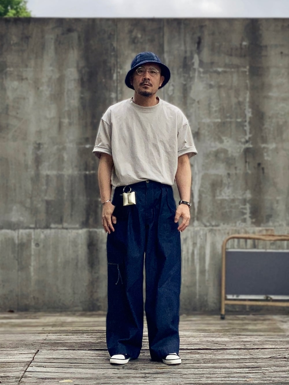 グレー系のTシャツ/カットソー、ブルー系のデニムパンツ、ブラック系のスニーカーを着用したメンズの春コーディネートの3枚目の写真