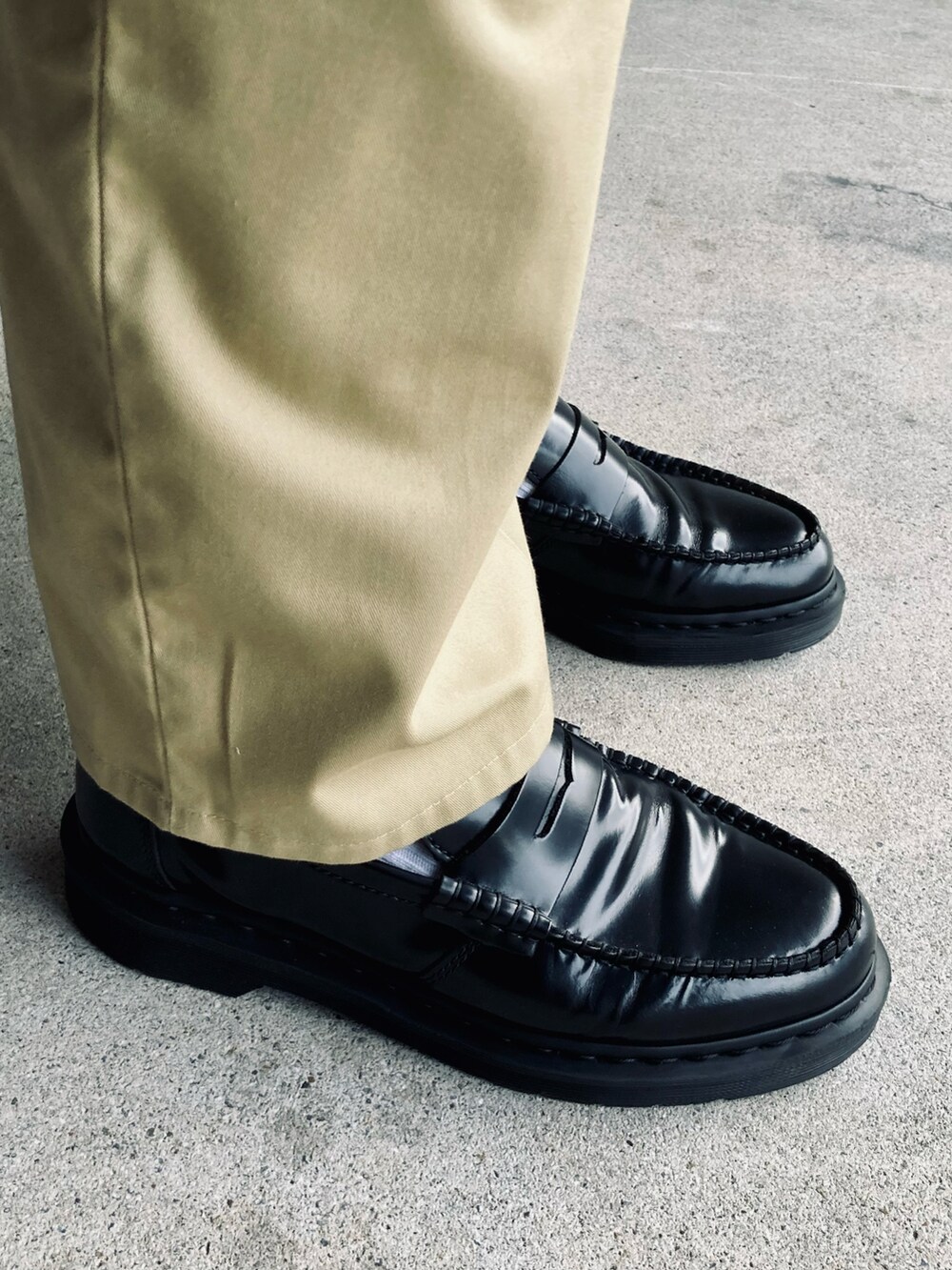 ホワイト系のTシャツ/カットソー、ベージュ系のチノパンツ、ブラック系のローファーを着用したメンズの夏コーディネートの3枚目の写真