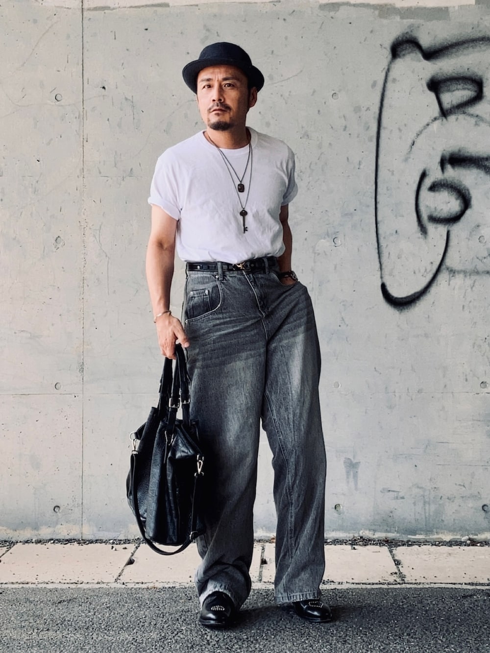 ホワイト系のTシャツ/カットソー、グレー系のデニムパンツ、ブラック系のドレスシューズを着用したメンズの秋コーディネートの3枚目の写真