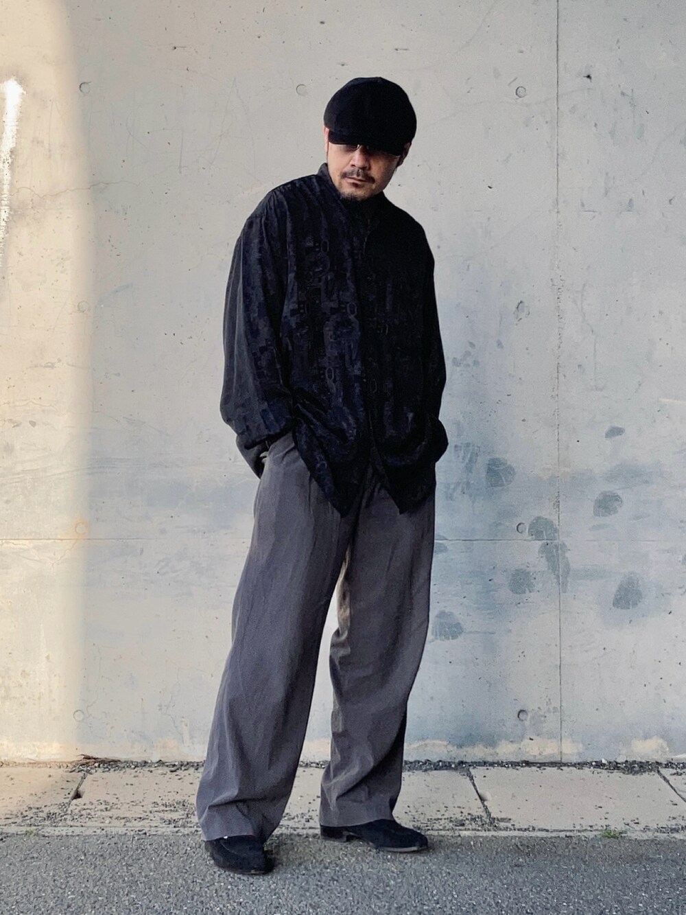 グレー系のスラックス、ブラック系のシャツ/ブラウス、ブラック系のローファーを着用したメンズの春コーディネートの4枚目の写真