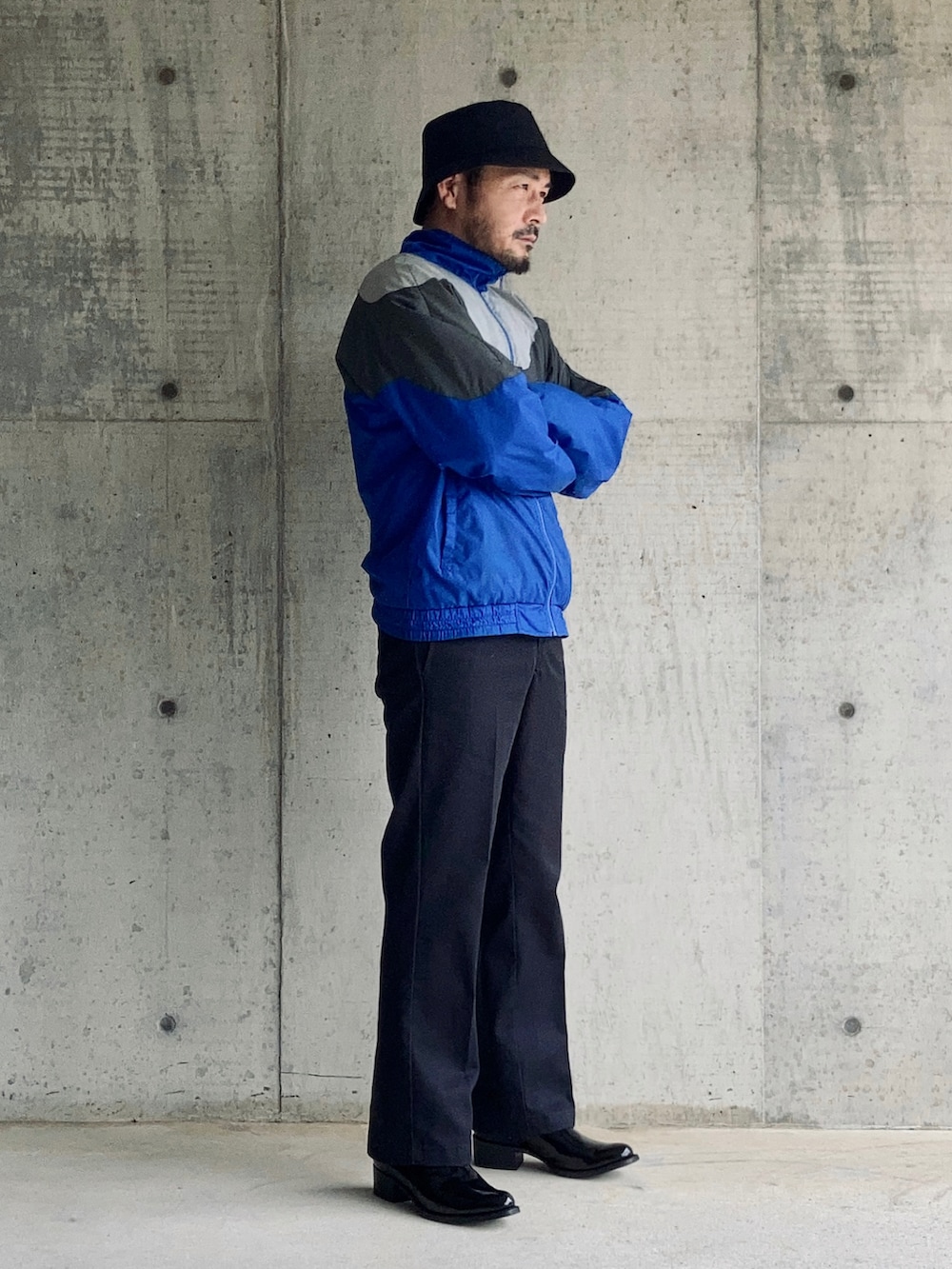 ブルー系のナイロンジャケット、ブルー系のチノパンツ、ブラック系のブーツを着用したメンズの秋コーディネートの3枚目の写真