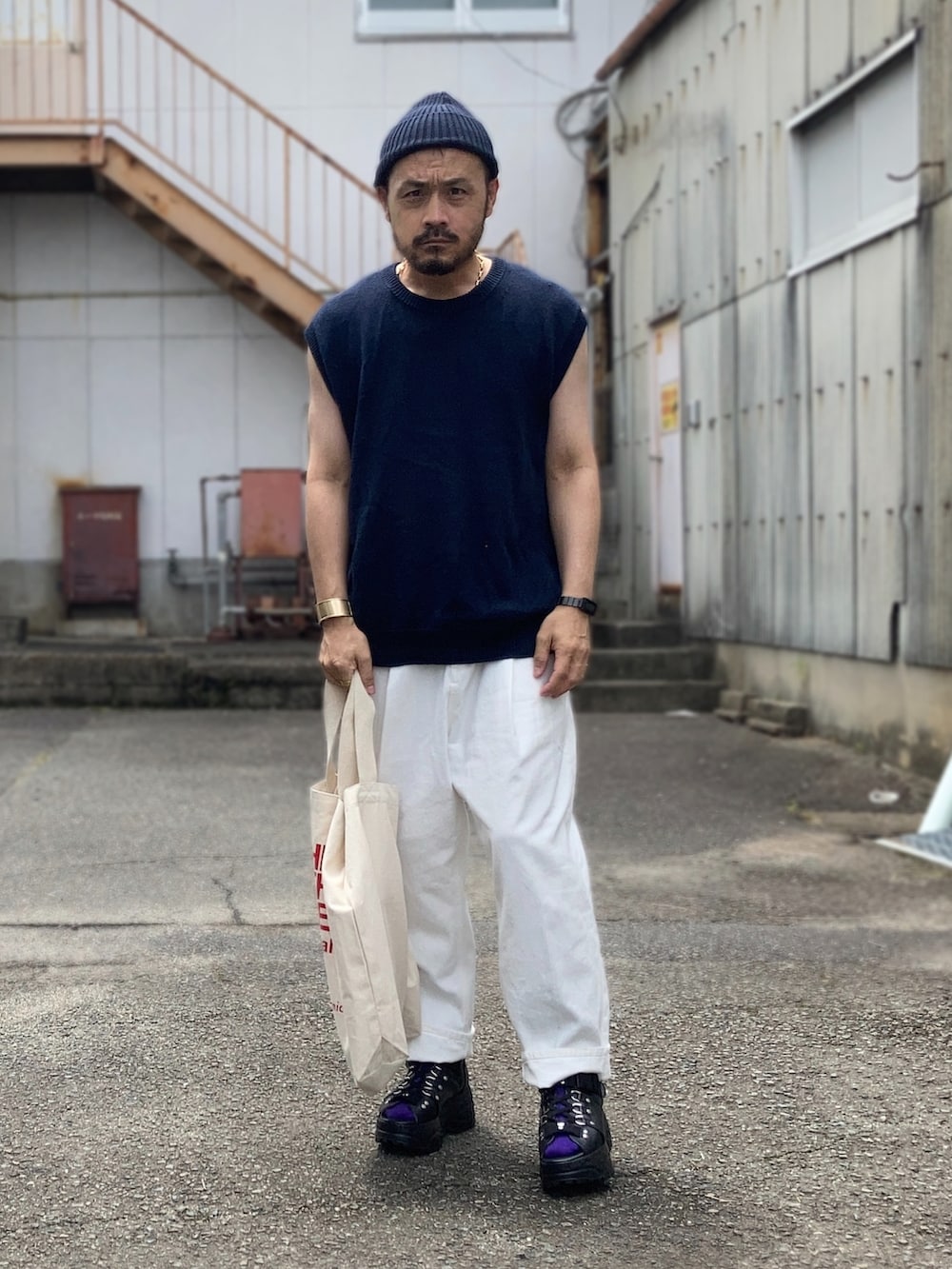 ブルー系のベスト、ホワイト系のスラックス、ブラック系のサンダルを着用したメンズの夏コーディネートの4枚目の写真