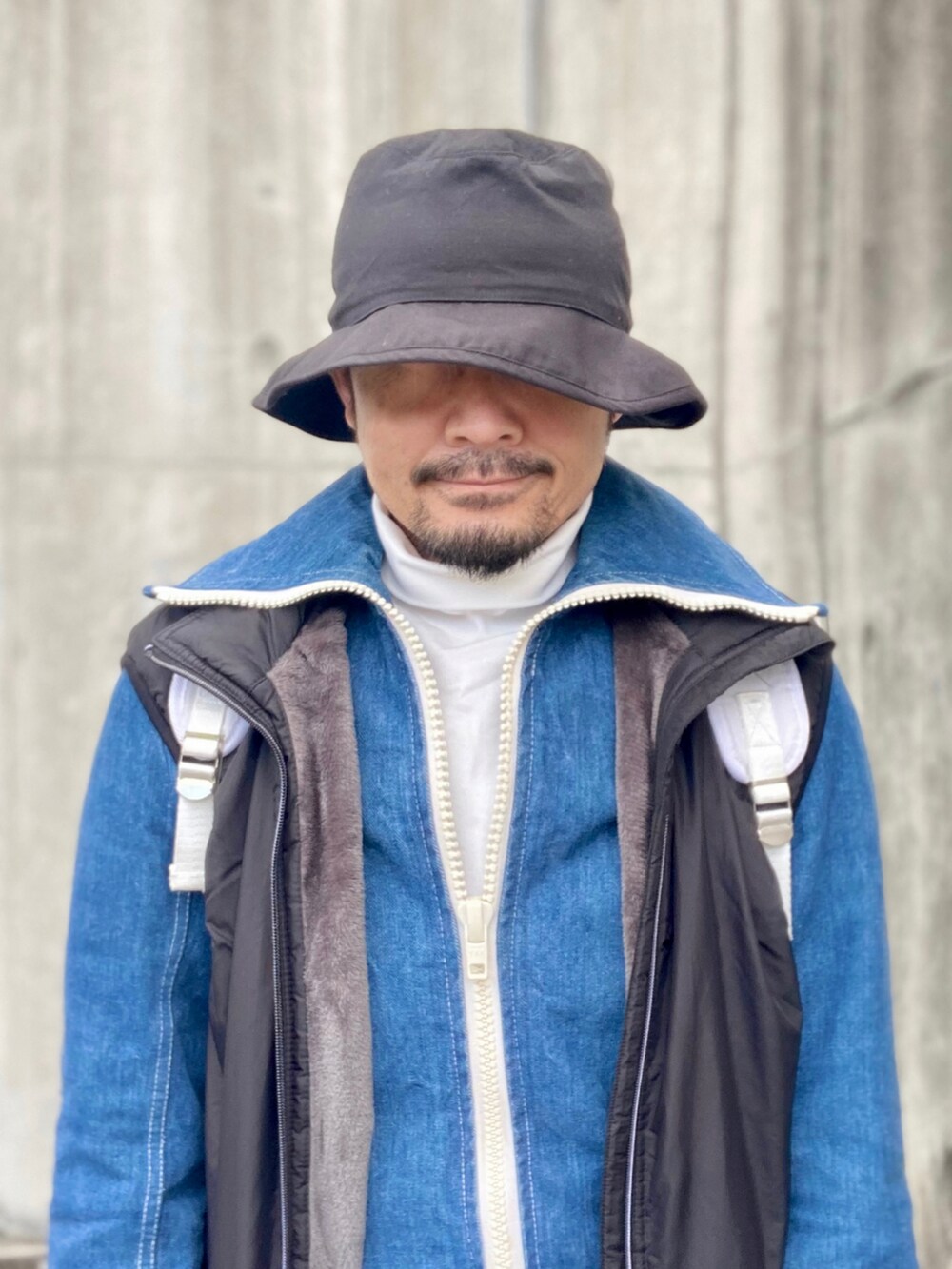 ホワイト系のTシャツ/カットソー、ブルー系のデニムジャケット、ブラック系のベストを着用したメンズの冬コーディネートの5枚目の写真