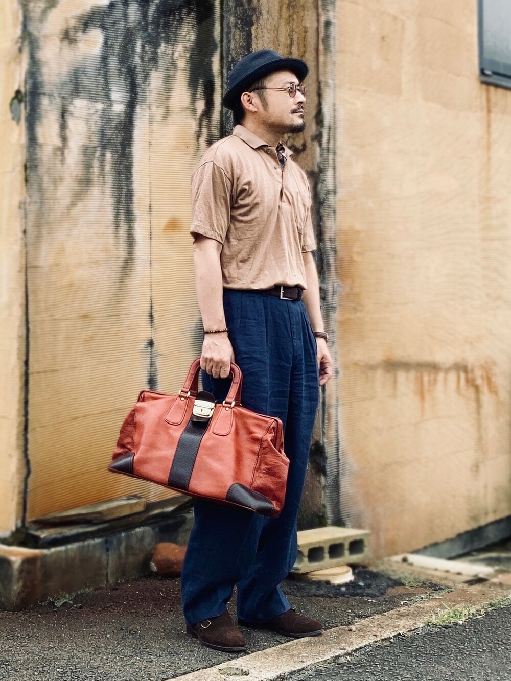 ブラウン系のポロシャツ、ブラウン系のドレスシューズ、ブラウン系のボストンバッグを着用したメンズの夏コーディネートの3枚目の写真