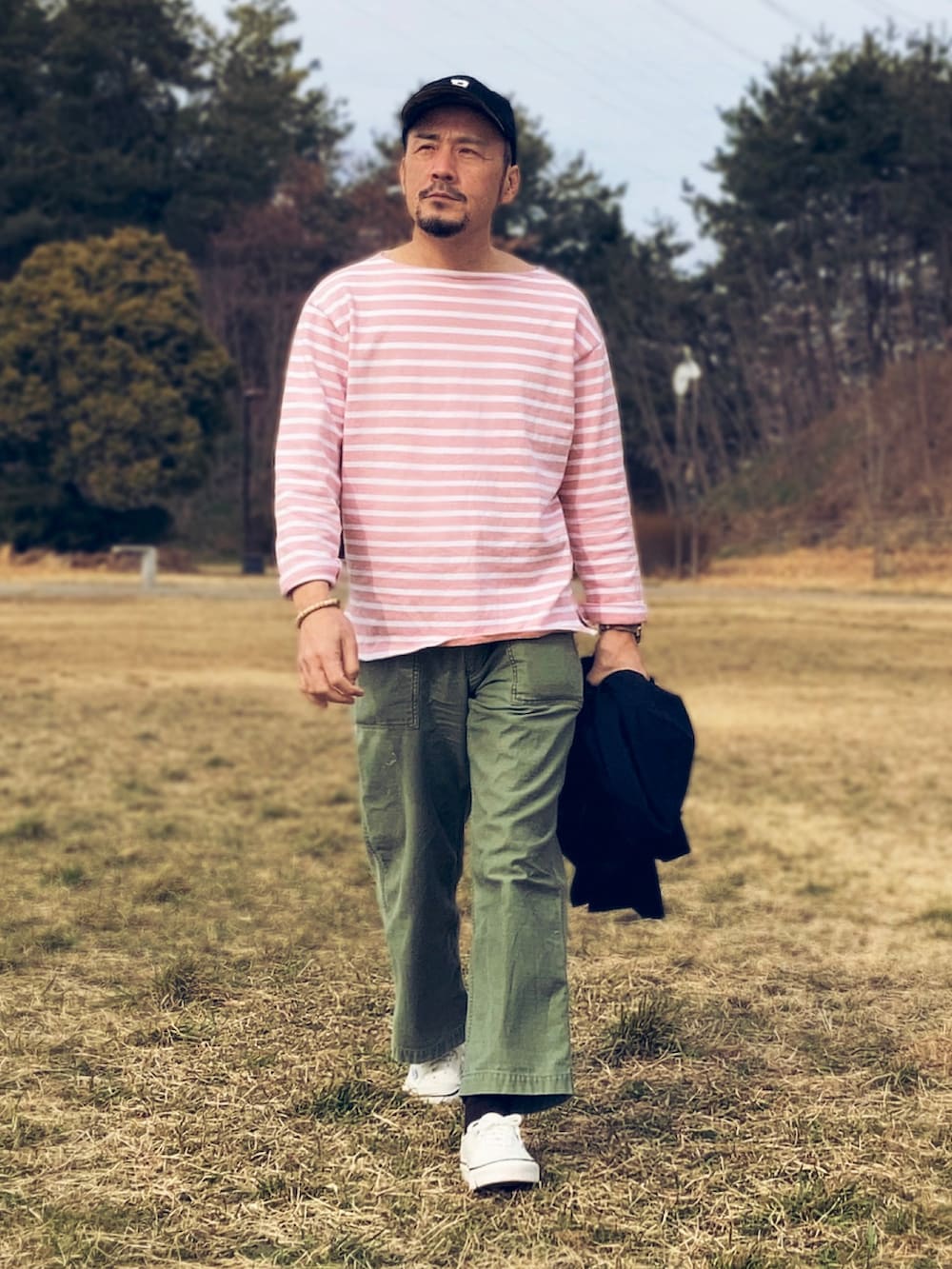 ピンク系のTシャツ/カットソー、ブルー系のテーラードジャケット、グリーン系のパンツを着用したメンズの春コーディネートの2枚目の写真