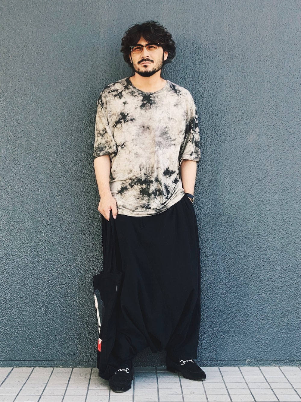 ブラウン系のTシャツ/カットソー、ブラック系のその他パンツ、ブラック系のトートバッグを着用したメンズの夏コーディネートの2枚目の写真