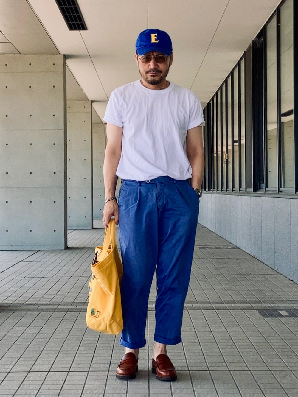 ホワイト系のTシャツ/カットソー、ブルー系のスラックス、ブラウン系のローファーを着用したメンズの夏コーディネートの2枚目の写真