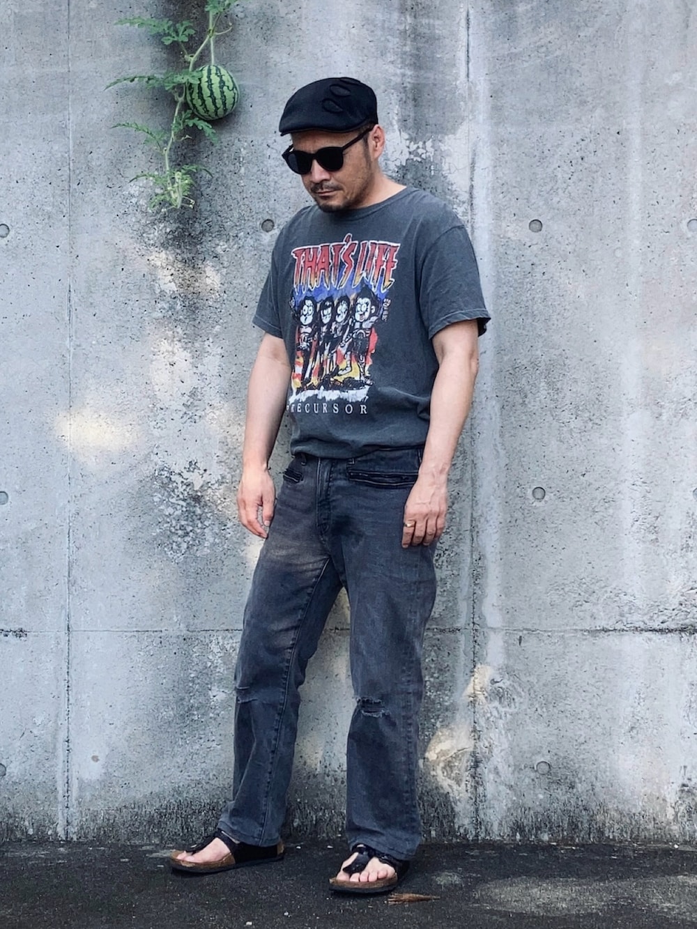 グレー系のTシャツ/カットソー、グレー系のデニムパンツ、ブラック系のサンダルを着用したメンズの夏コーディネートの3枚目の写真