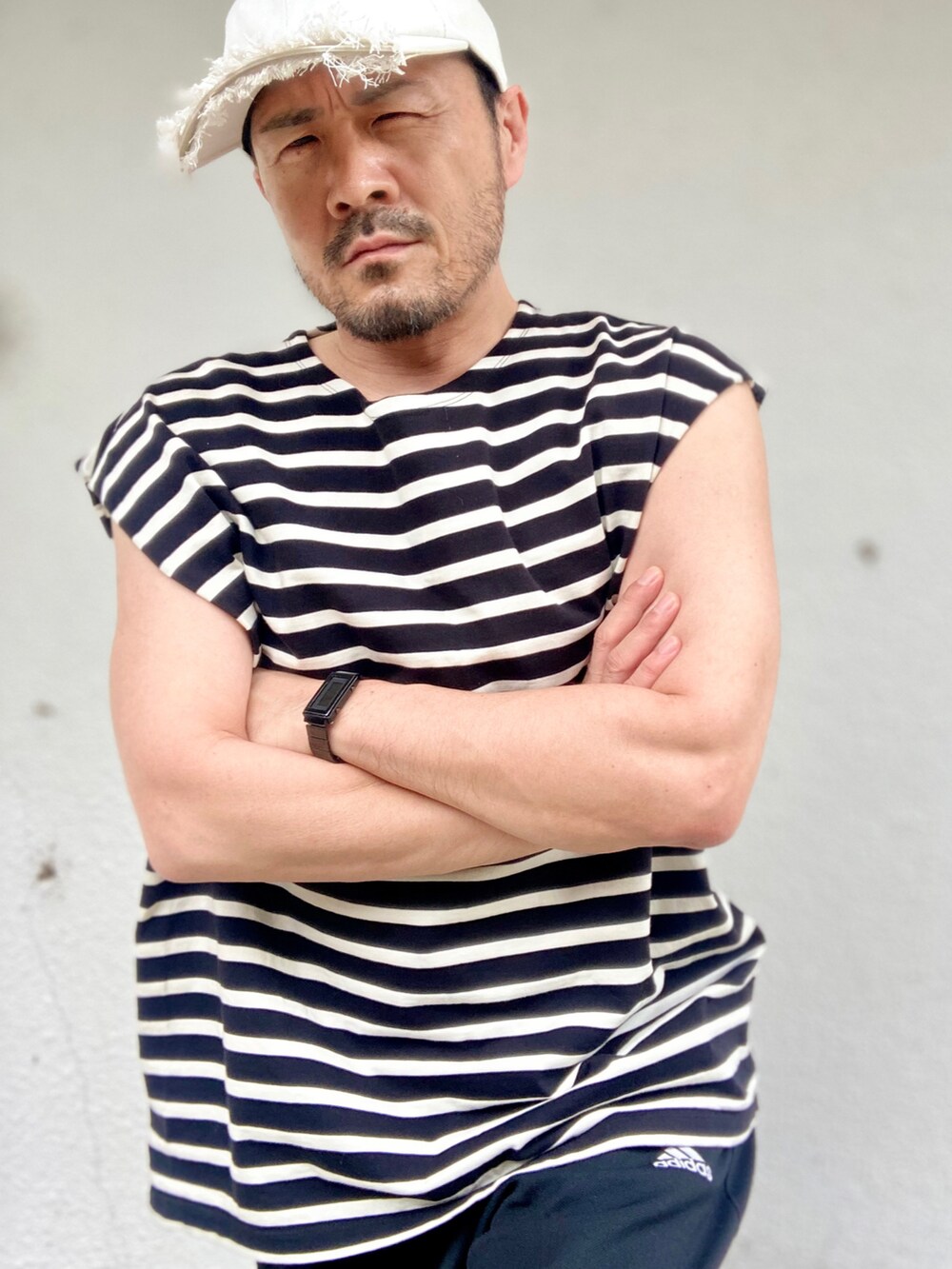 ブラック系のTシャツ/カットソー、ブラック系のパンツ、ブラック系のサンダルを着用したメンズの夏コーディネートの5枚目の写真