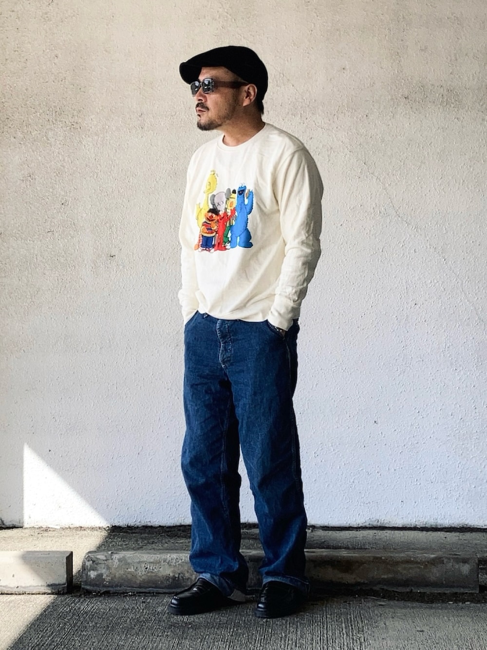 ホワイト系のパーカー、ブルー系のデニムパンツ、ブラック系のローファーを着用したメンズの春コーディネートの3枚目の写真