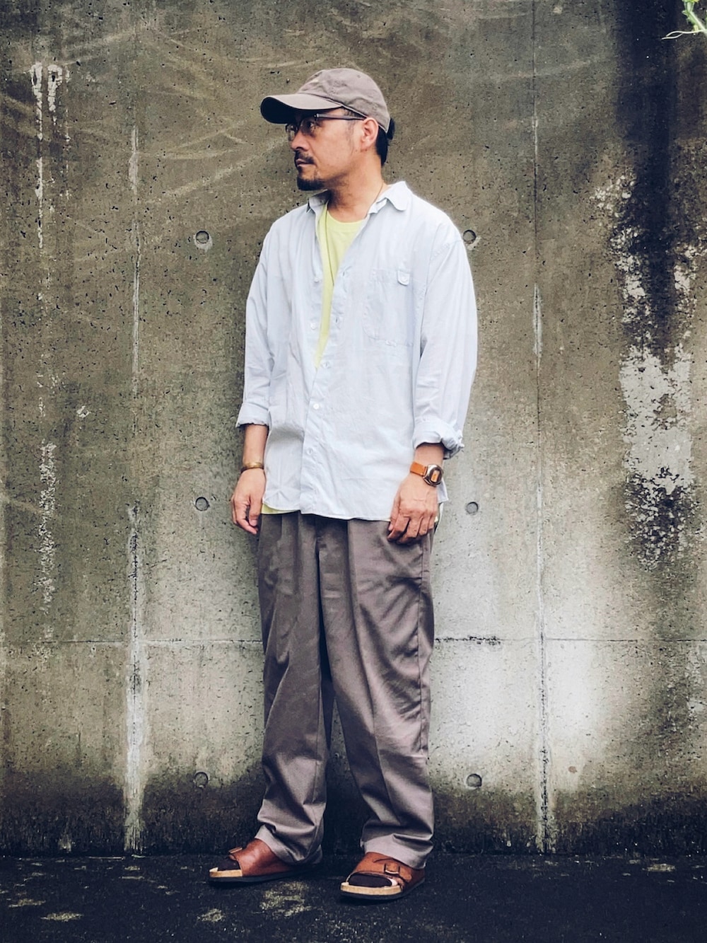 ブルー系のシャツ/ブラウス、グレー系のスラックス、ブラウン系のサンダルを着用したメンズの夏コーディネートの2枚目の写真