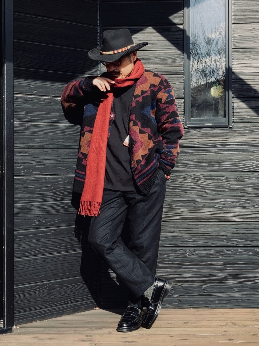 ブラック系のTシャツ/カットソー、ブラック系のカーディガン/ボレロ、ブラック系のスラックスを着用したメンズの冬コーディネートの2枚目の写真