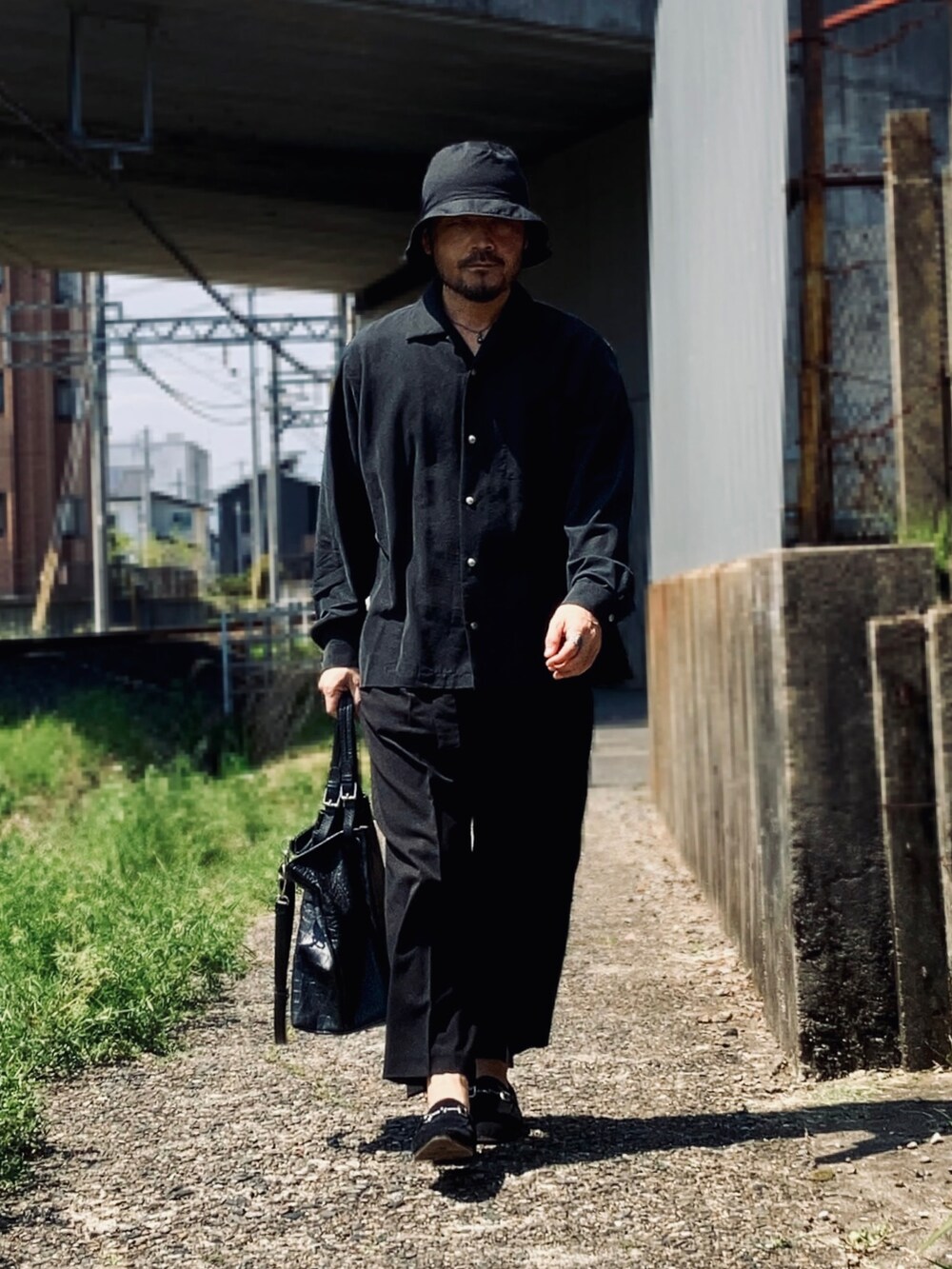 ブラック系のシャツ/ブラウス、ブラック系のスラックス、ブラック系のローファーを着用したメンズの春コーディネートの2枚目の写真