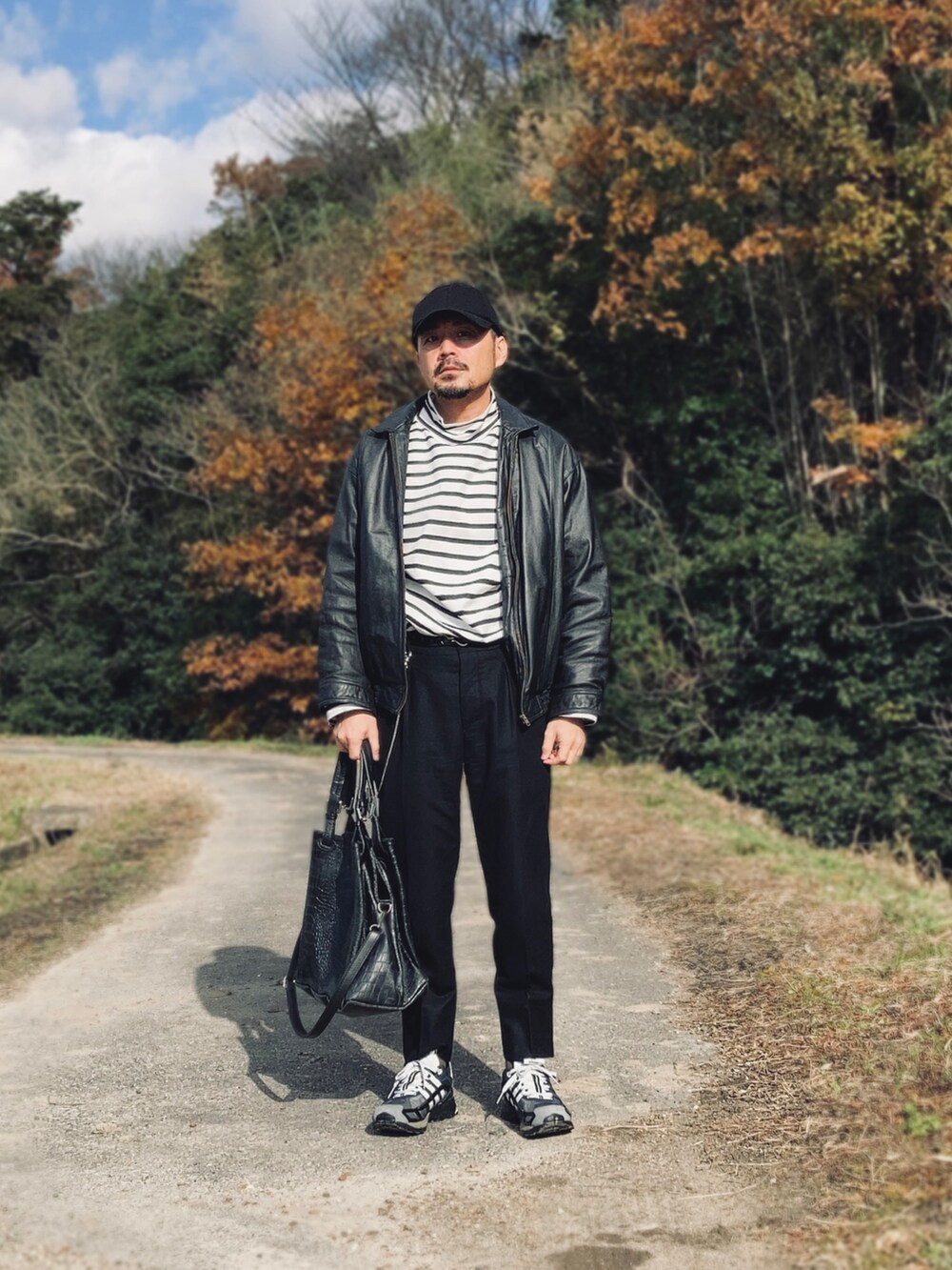 ブラック系のTシャツ/カットソー、ブラック系のブルゾン、ブラック系のスラックスを着用したメンズの冬コーディネートの4枚目の写真