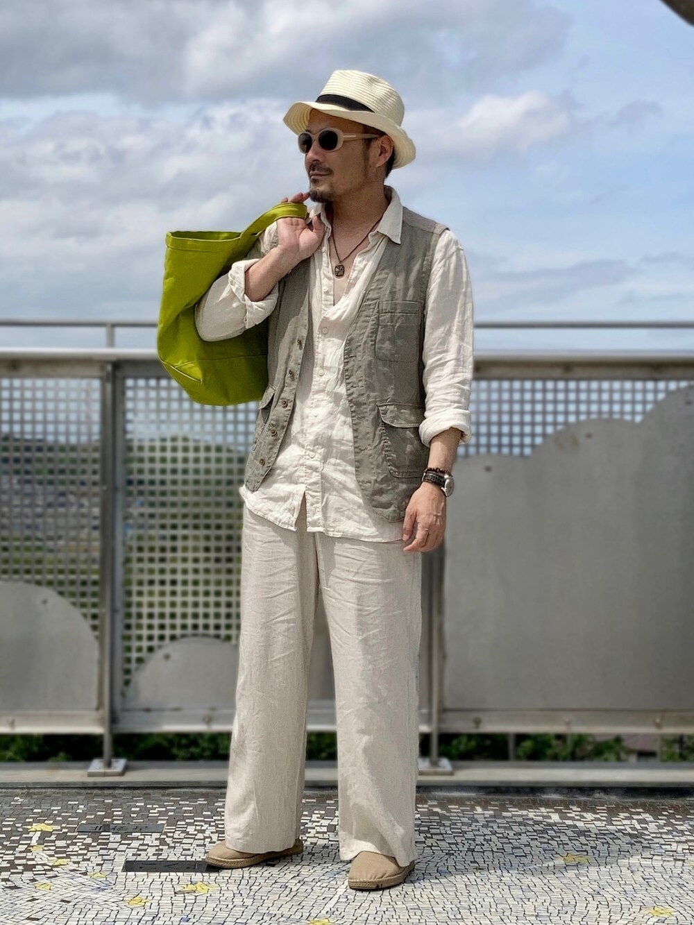 ベージュ系のシャツ/ブラウス、グリーン系のベスト、ベージュ系のパンツを着用したメンズの春コーディネートの3枚目の写真